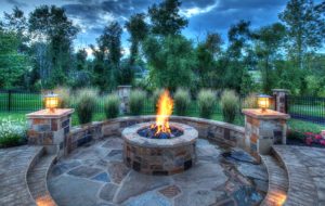 A pool with entertainment centers, outdoor kitchens, fountains, and waterfalls built by Backyard by Design Kansas City