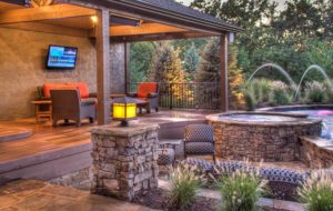 An Entertainer's Delight in Parkville pool and spa with waterfall and fountains with outdoor living space by Backyard by Design KC