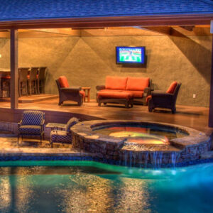 A pool with spa, cabana and tv