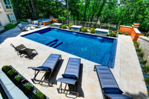Beautiful pool with patio furniture and landscaping.