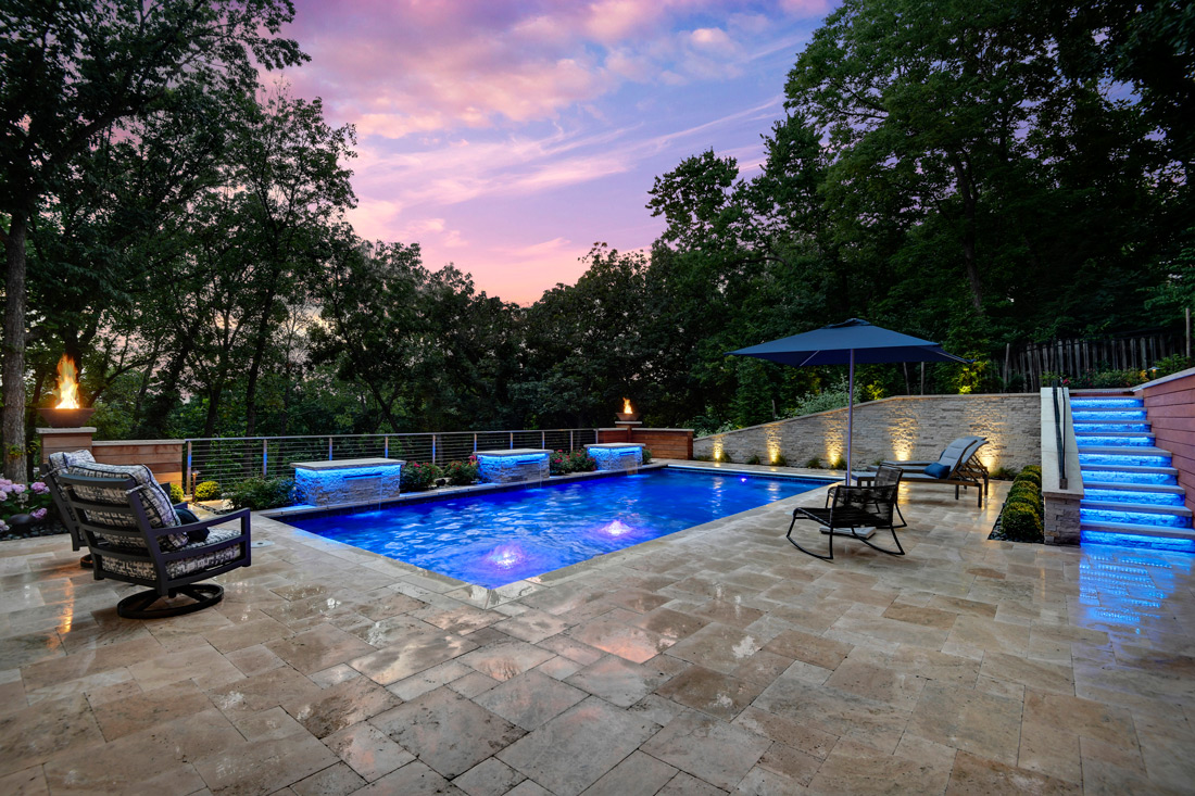 Backyard pool with patio furniture and lighting