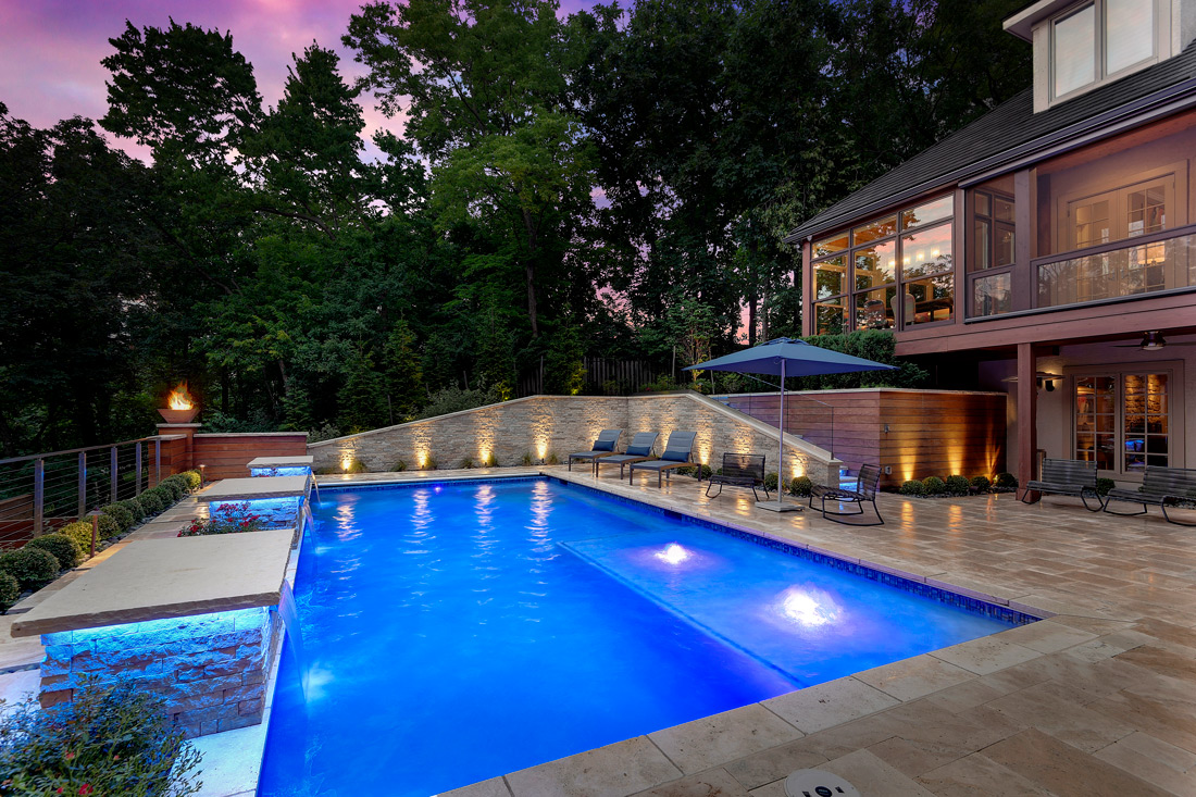 Backyard by design lighting and pool patio with fruniture